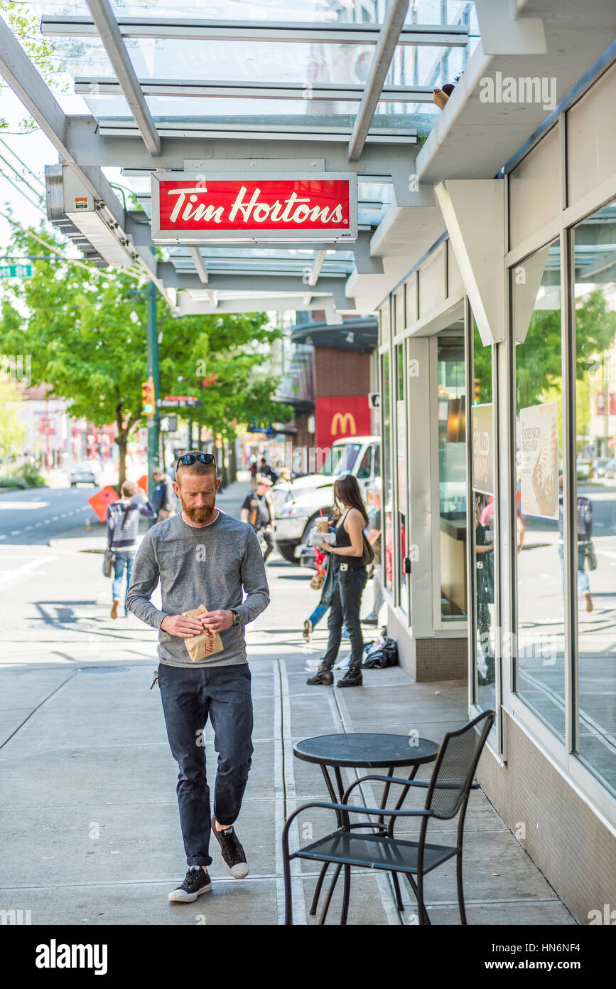 Vancouver, Kanada - 19. April 2016: Man walking von Tim Hortons Restaurant mit Essen in der Innenstadt von Stockfoto