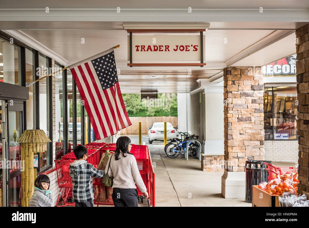 Fairfax, USA – 25. November 2016: Trader Joes Lebensmittelgeschäft Eingang mit Zeichen, amerikanische Flagge und Passanten Stockfoto