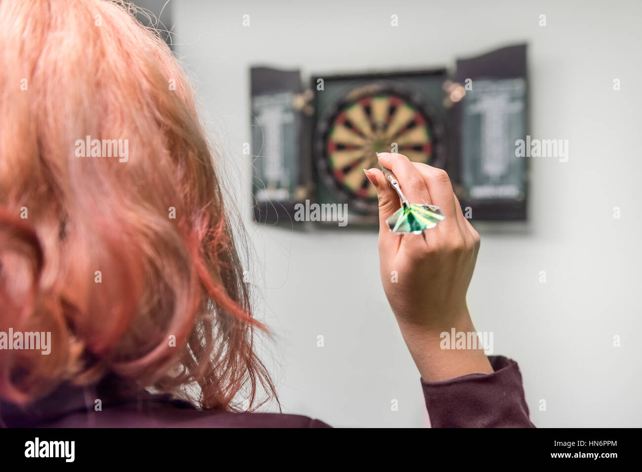 Nahaufnahme des Mädchens Kopf und Hand wirft einen dart Stockfoto