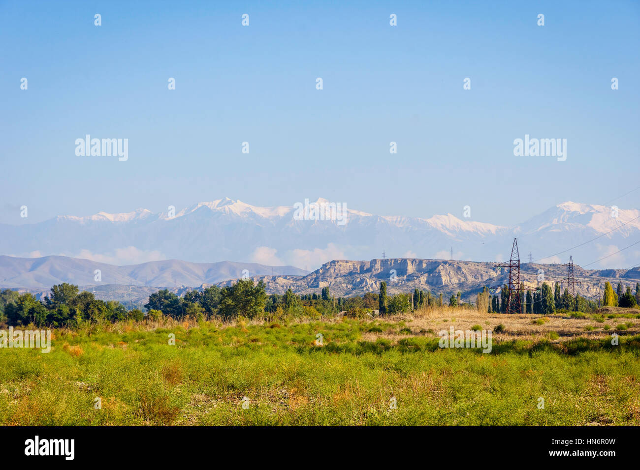 Fluss, grüne Wiese, Felder und Berge mit schneebedeckten Gipfeln, erstaunliche Landschaften von Aserbaidschan Stockfoto