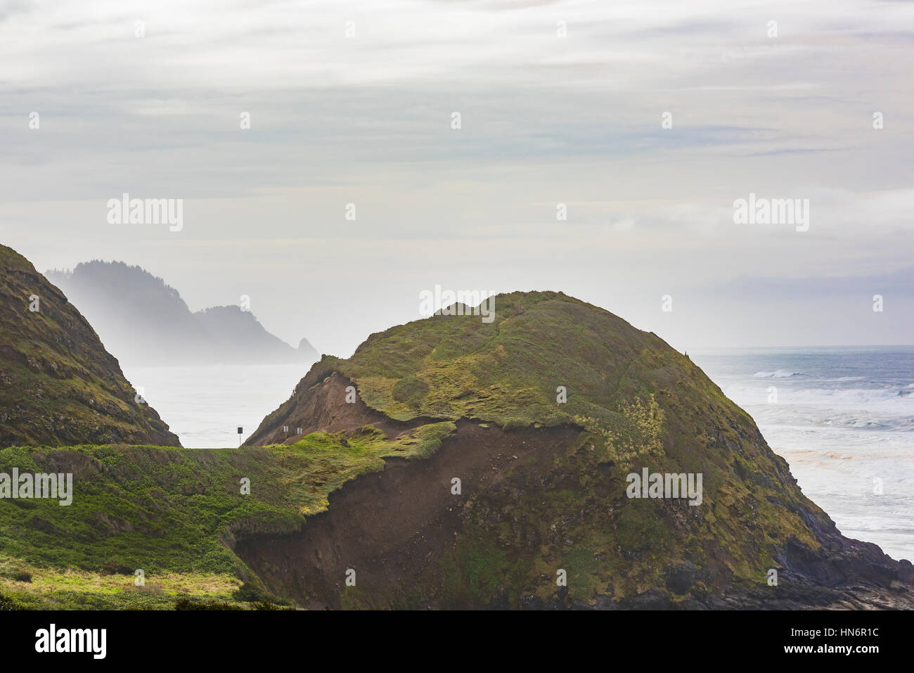Misty und Foggy Oregon Coast Klippen und Wälder mit Hill und Straße Stockfoto