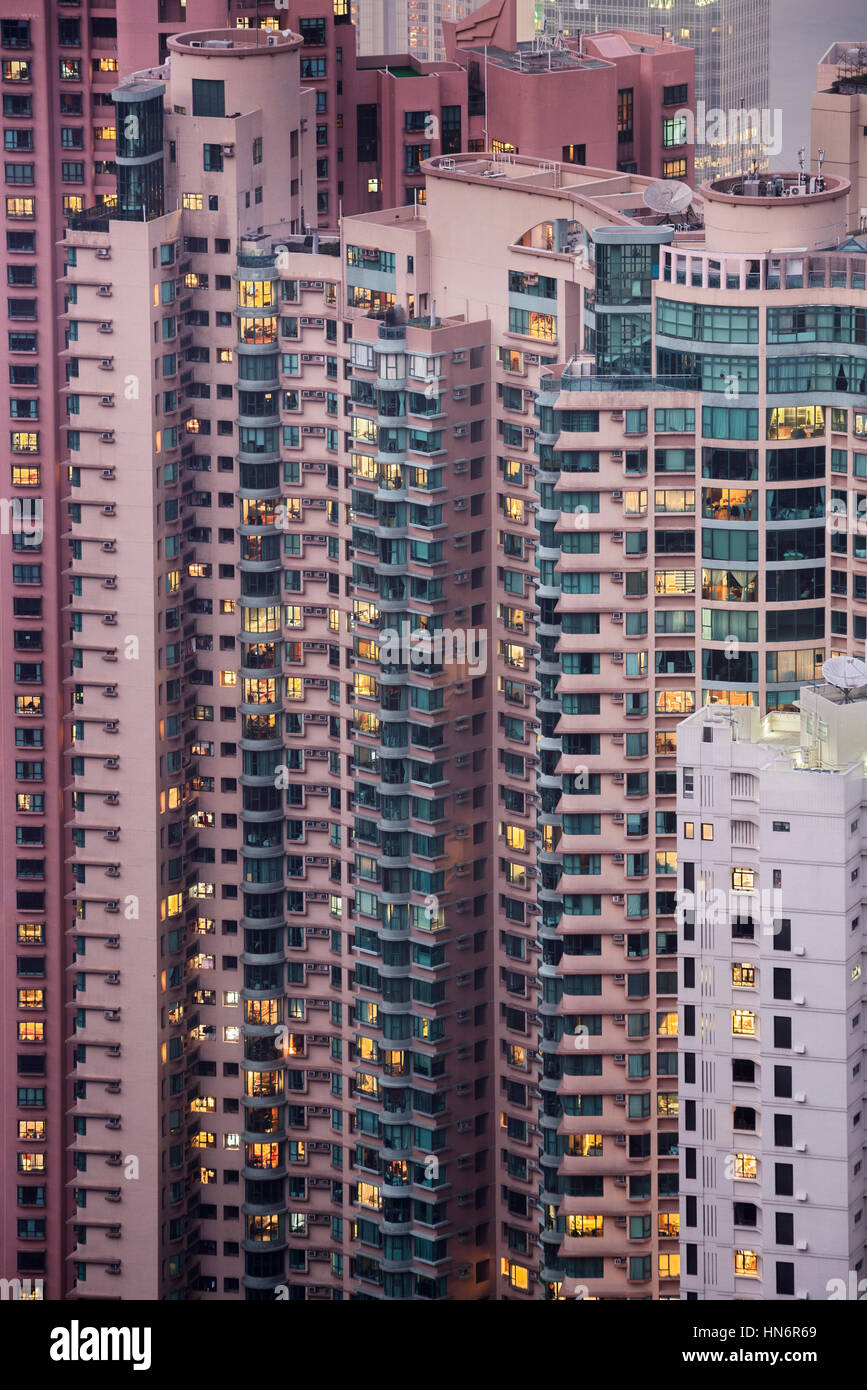 Detailansicht der Skyskraper in einer dicht besiedelten Stadt. Hochhäuser mit Wohnblocks in der Nacht. Hongkong, China Stockfoto
