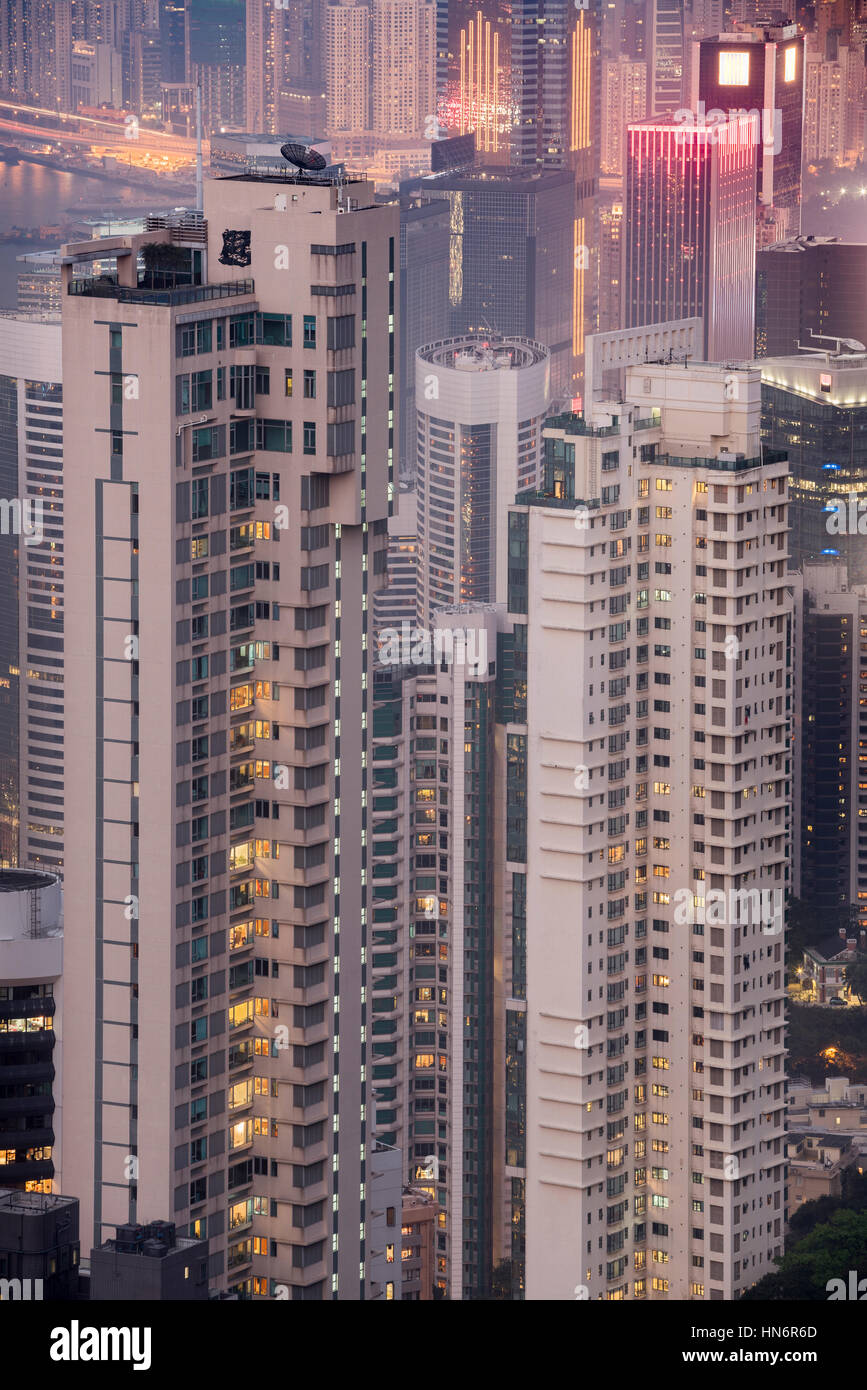 Detailansicht der Skyskraper in einer dicht besiedelten Stadt. Hochhäuser mit Wohnblocks in der Nacht. Hongkong, China Stockfoto