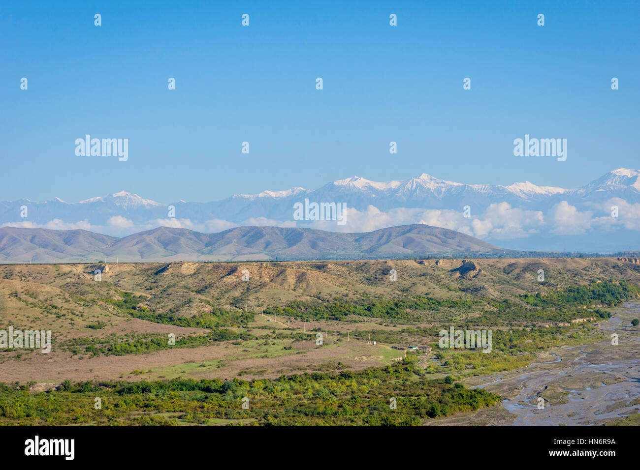 Fluss, grüne Wiese, goldene Felder und Berge mit schneebedeckten Gipfeln, erstaunliche Landschaften von Aserbaidschan Stockfoto