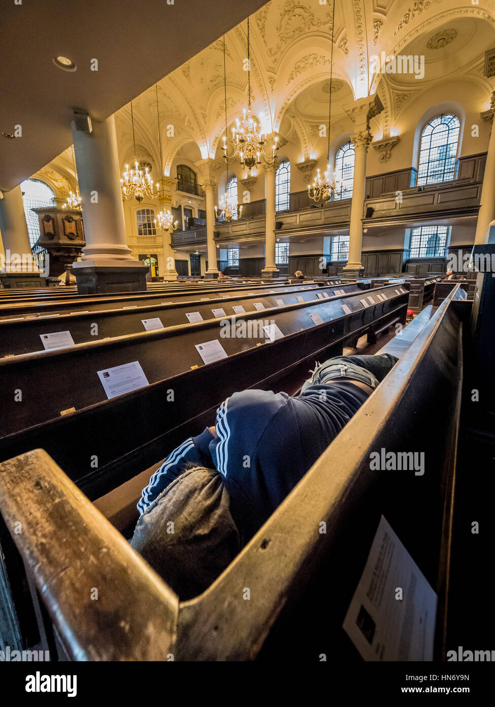 Obdachloser schlafen in Kirchenbänken der St. Martin-in-the-Fields, englische anglikanische Kirche an der Nordost-Ecke des Trafalgar Square in der Stadt Westm Stockfoto