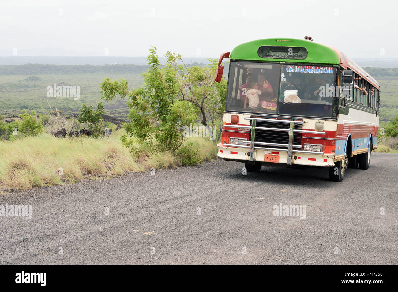 Masaya, Nicaragua - 24. Juli 2015: Alte bunte Huhn Bus vollgepackt mit Menschen macht seinen Weg auf der asphaltierten Straße zu den Kratern von Masaya und Nindiri v Stockfoto