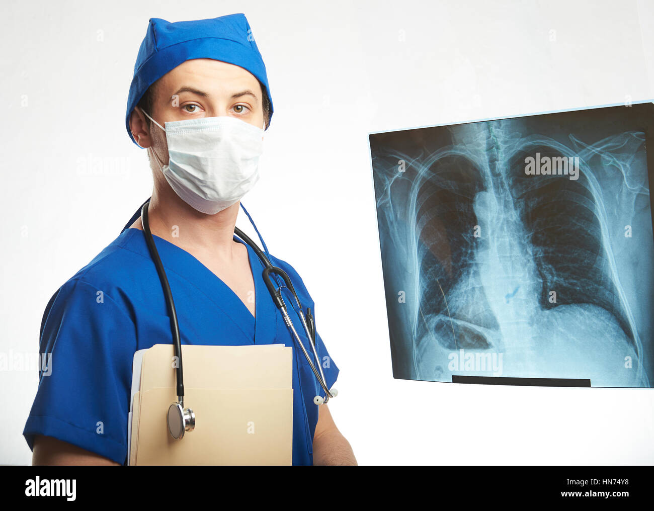 Arzt Radiologe in Maske mit Röntgenbild der Lunge isoliert auf weiss Stockfoto