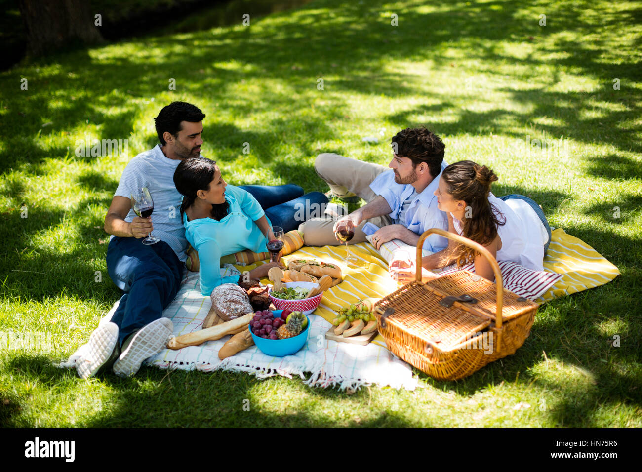 Glückliche Paare interagieren und dabei ein Glas Wein im park Stockfoto