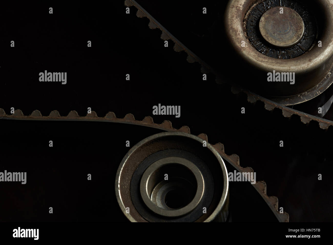 Zahnriemen und Rollen auf schwarzem Hintergrund hautnah Stockfoto