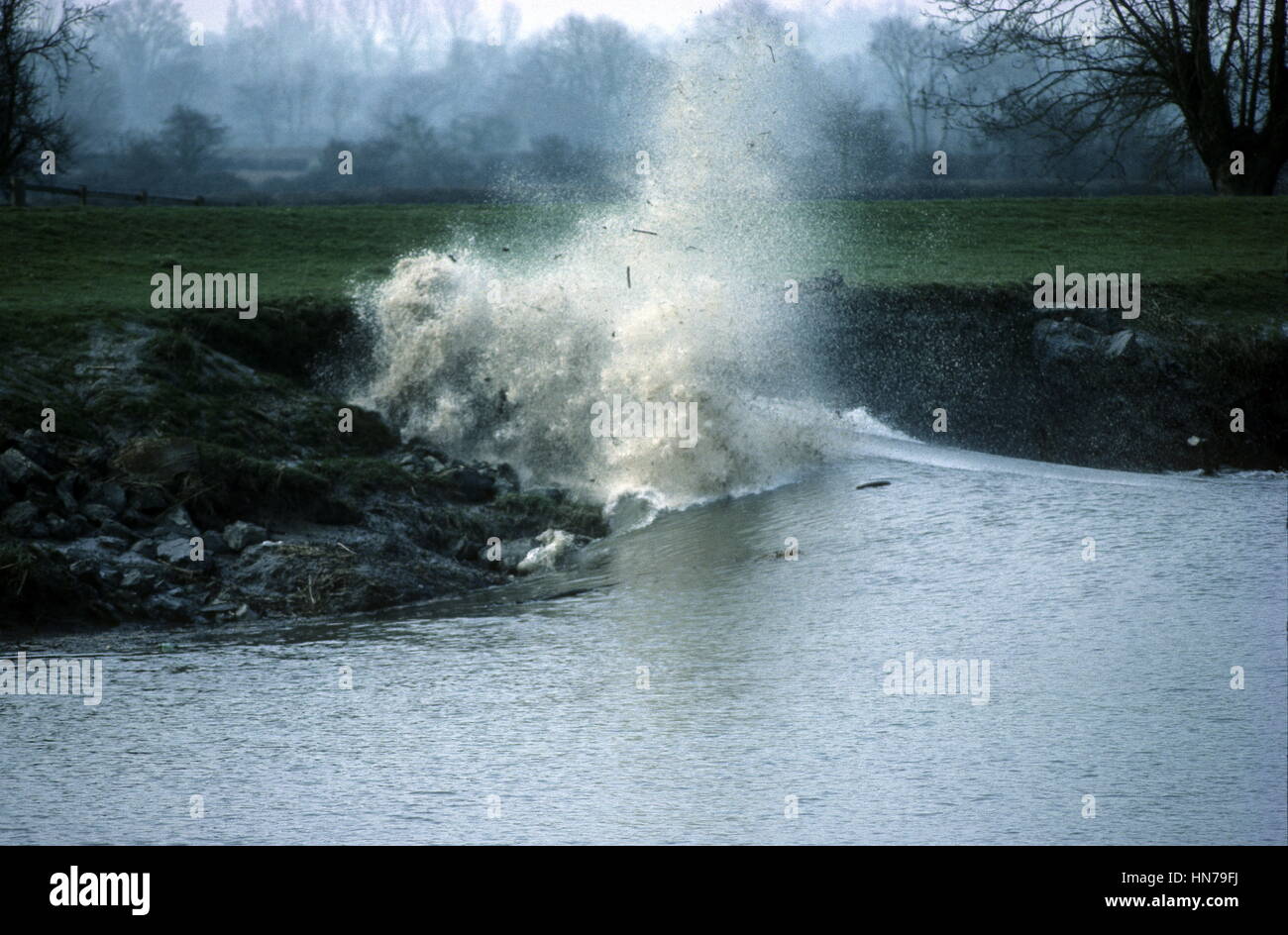 Flutwelle bricht entlang Ufer werfen Schutt in die Luft über den Fluss Severn Stockfoto