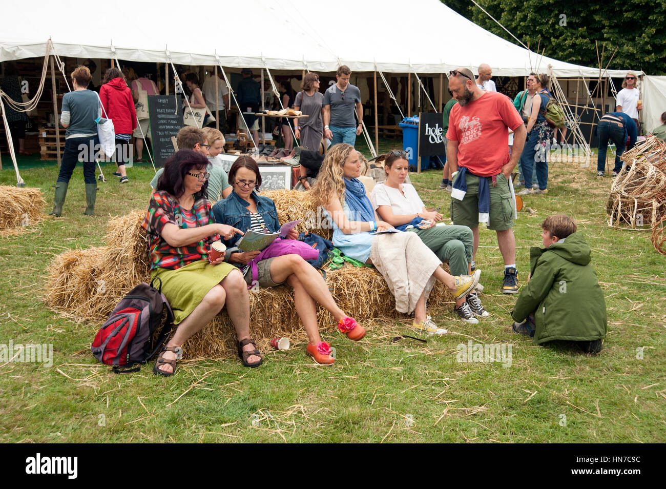 Im mittleren Alter festival Trinker sitzen auf einem Ballen Heu am Hafen Eliot Sommer Festival Stockfoto