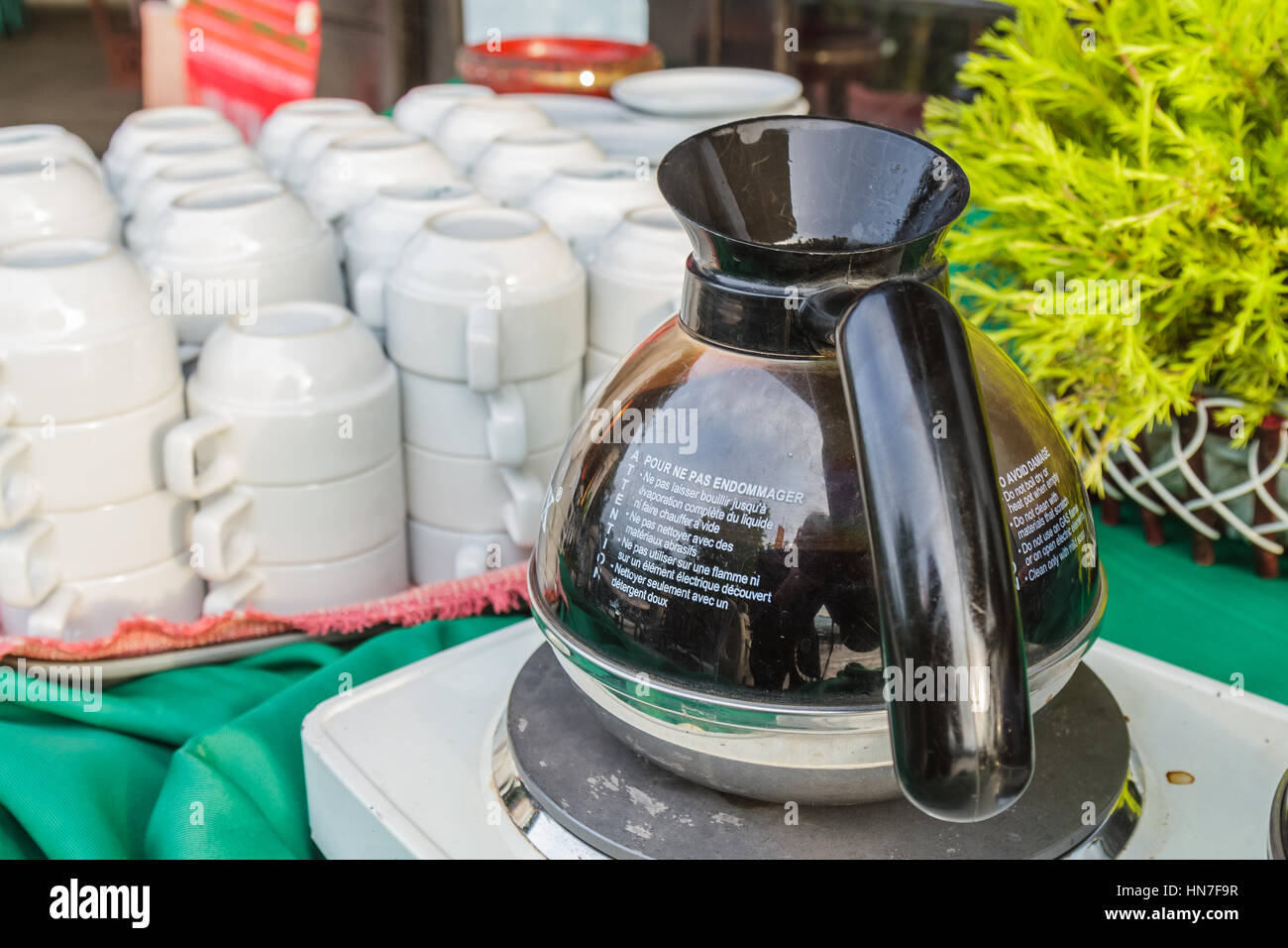 Schwarzer Kaffee im Topf und weiße Tassen im Restaurant. Stockfoto