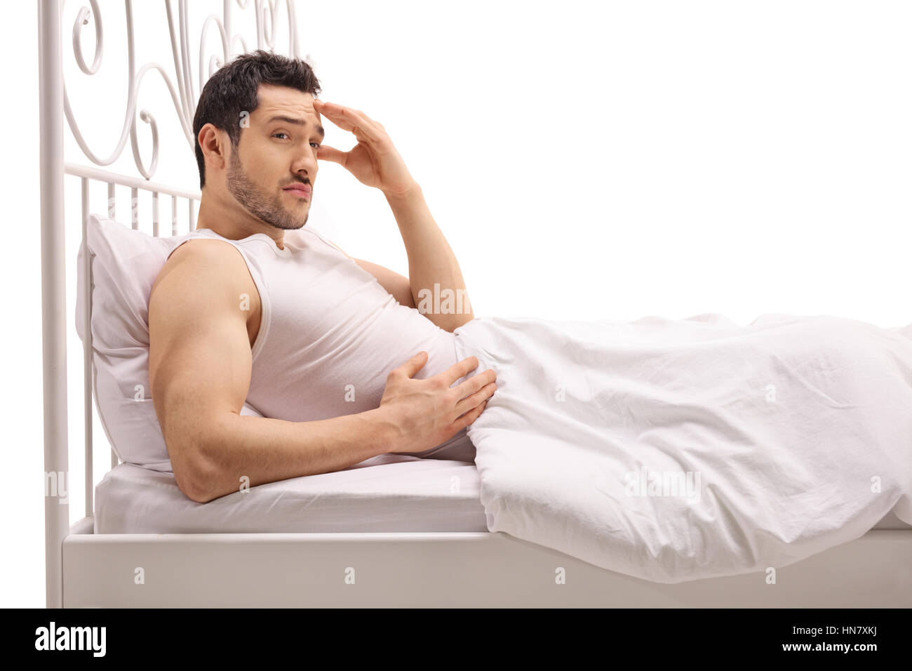 Besorgt Kerl im Bett isoliert auf weißem Hintergrund Stockfoto