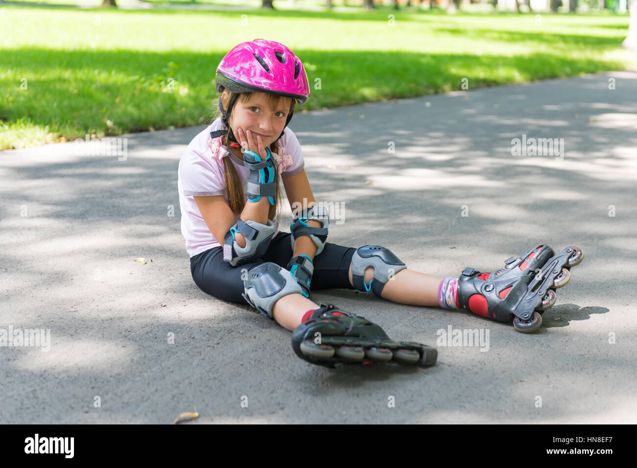Kleines Mädchen auf Rollschuhen im Sommerpark Stockfoto