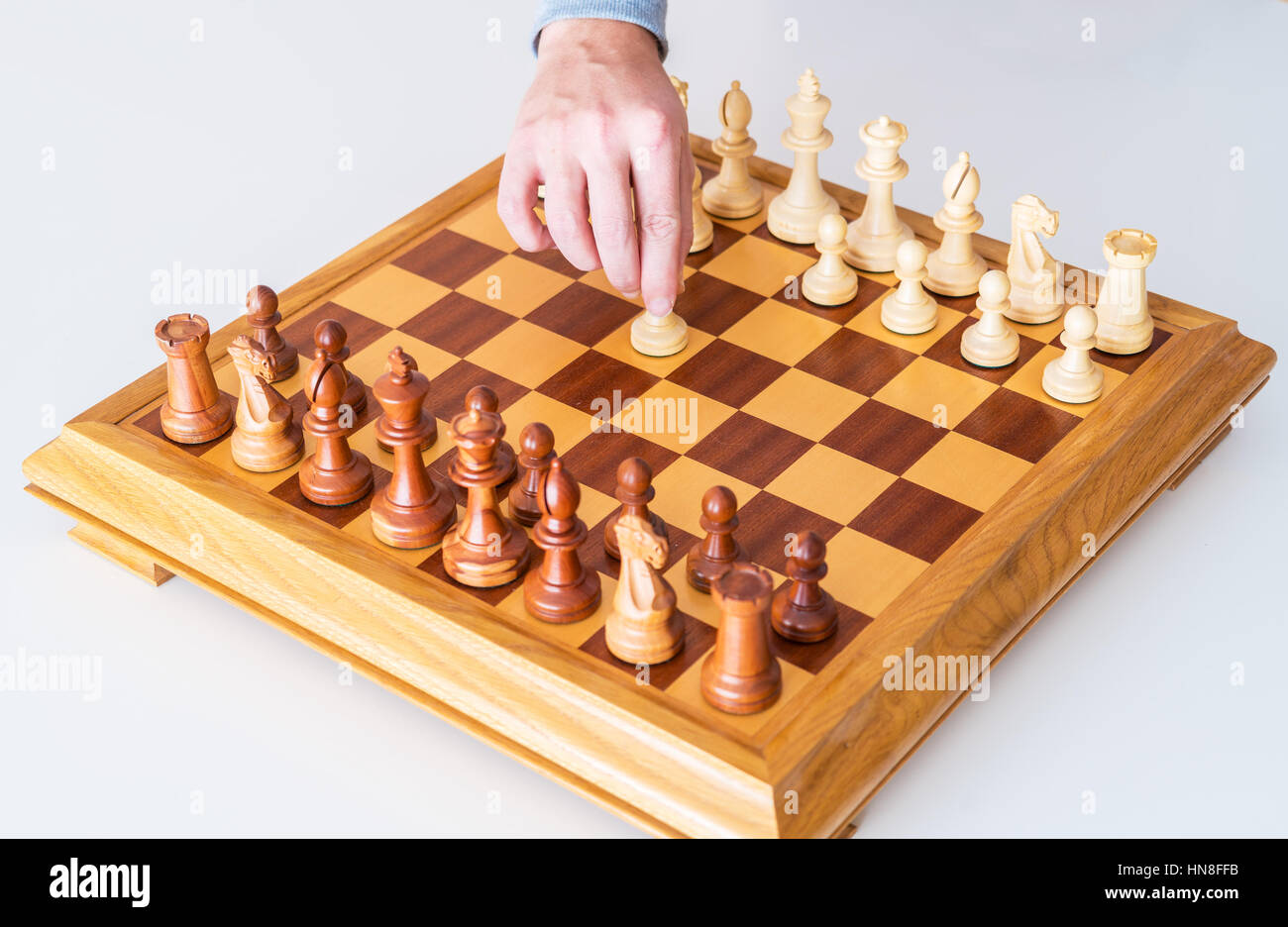 Der Anfang des Spiels - macht die Hand mit dem Bauern den ersten Schritt auf die Chess Board Stockfoto