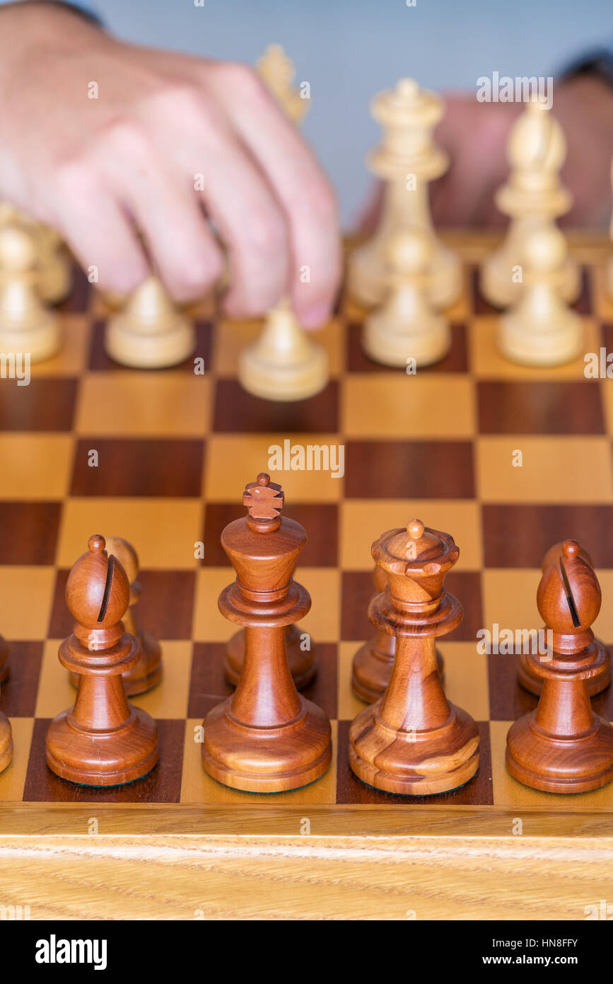 Der Anfang des Spiels - macht die Hand mit dem Bauern den ersten Schritt auf die Chess Board Stockfoto