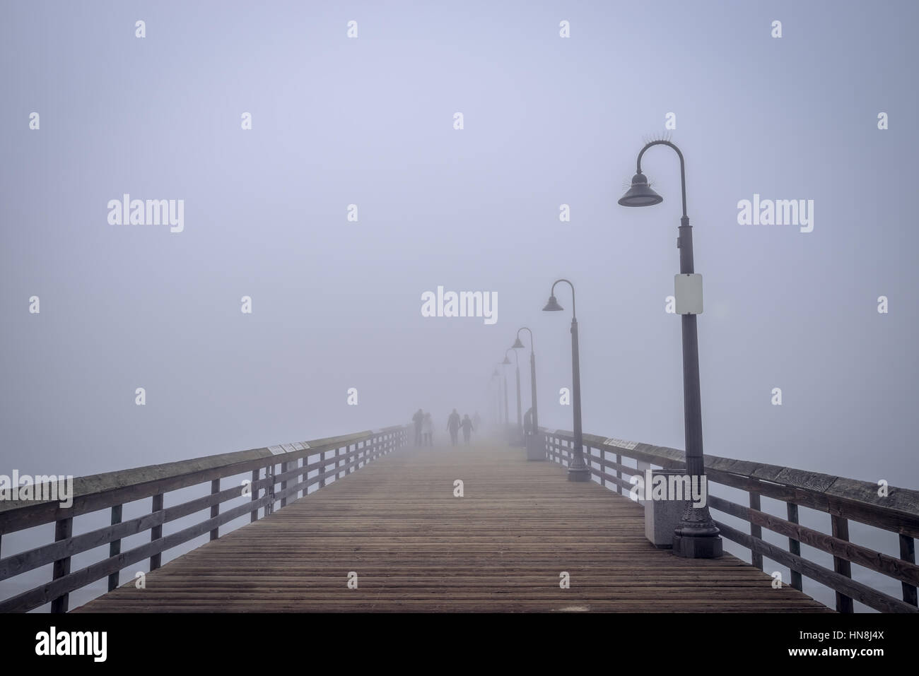 Silhouetten von Menschen im Nebel auf dem Imperial Beach Pier. Stockfoto