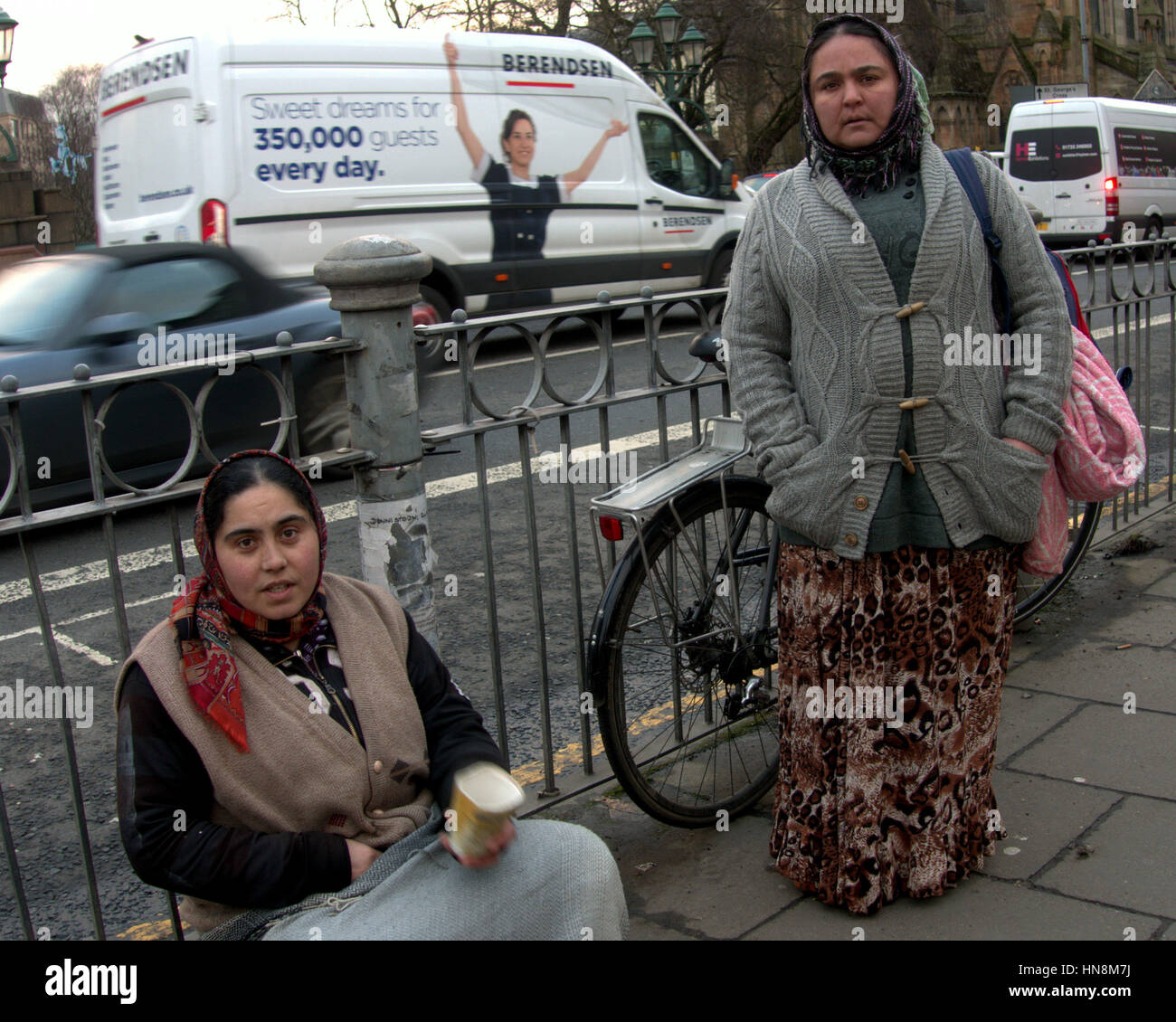 Asiatische Familie Flüchtling gekleidet Habib auf Straße in der UK alltägliche Szene betteln cup Stockfoto