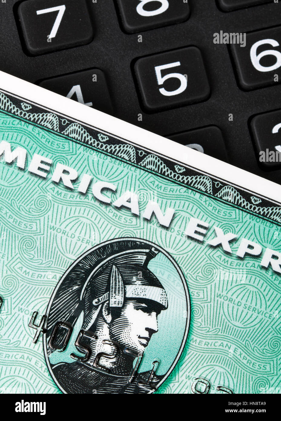 Nahaufnahme der grünen American Express Kreditkarte auf einen Ziffernblock. AMEX ist eines der größten Kreditkartengesellschaften weltweit Stockfoto