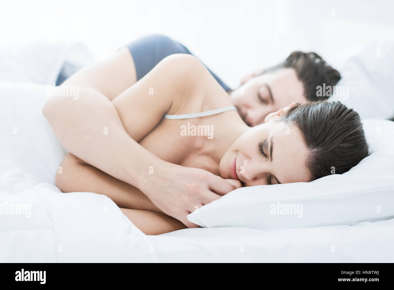 Glückliches junges Paar schlafend im Bett in den Morgen und umarmt, Liebe und Beziehungen-Konzept Stockfoto