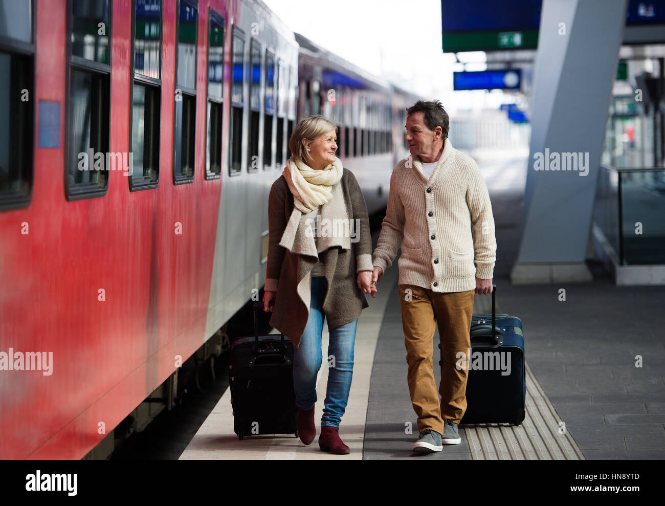 Älteres Paar am Bahnhof ziehen Trolley Gepäck. Stockfoto