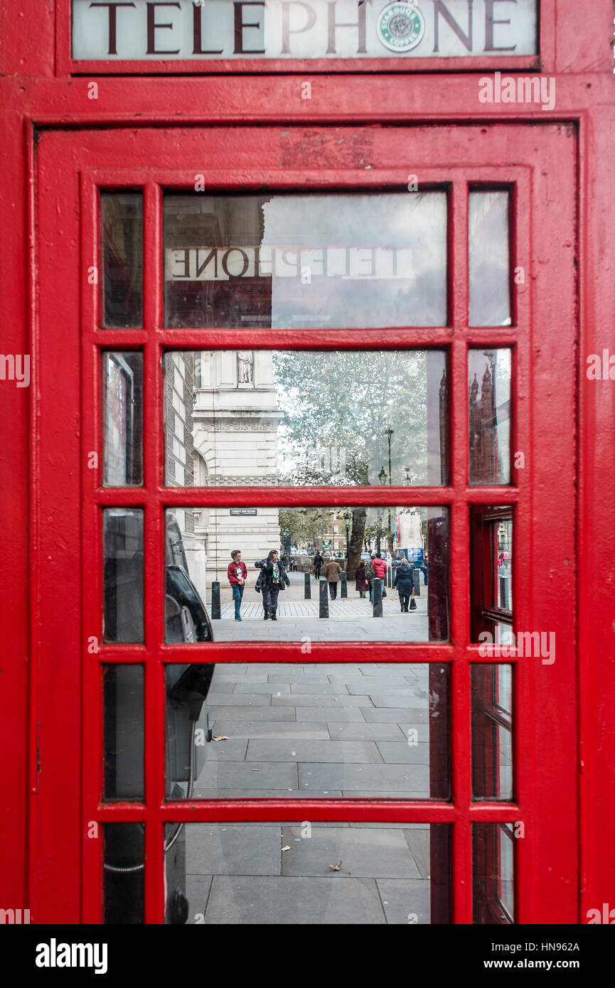 London, Vereinigtes Königreich - 20. Oktober 2016: Menschen sind auf der Straße neben der roten Telefonzelle in London Fuß. Stockfoto