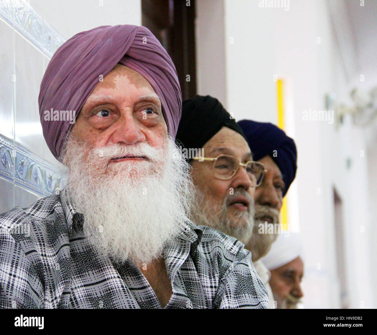 Ein älterer indischer Sikh-Mann mit einem langen weißen Bart, der einen Turban mit der Vitiligo-Hautstörung bei einer Sikh-Hochzeit in Malaysia trägt Stockfoto