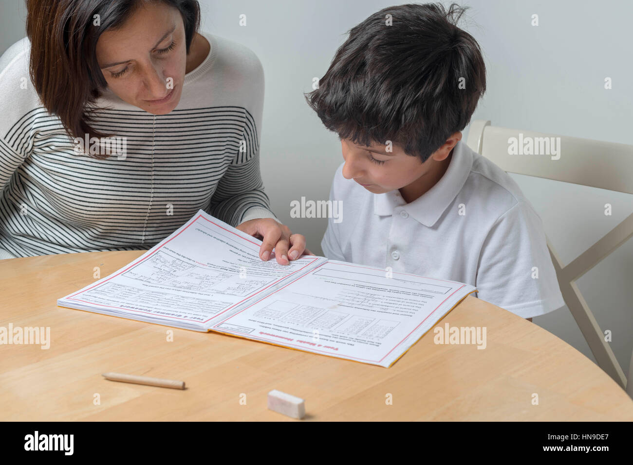 Mutter hilft 9-jähriger Schüler bei den Hausaufgaben, UK Stockfoto
