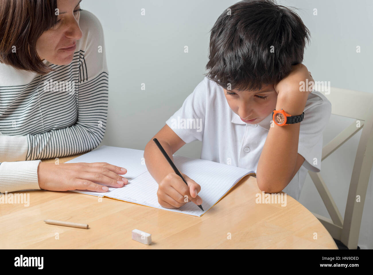 Mutter hilft 9-jähriger Schüler bei den Hausaufgaben, UK Stockfoto