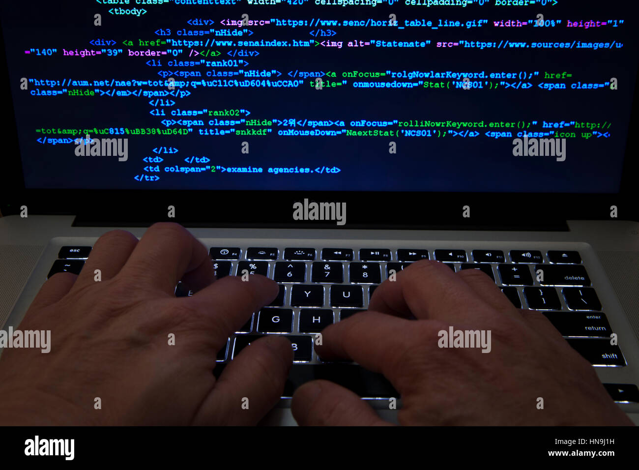 Mann, die Eingabe von Code auf Laptop-computer Stockfoto