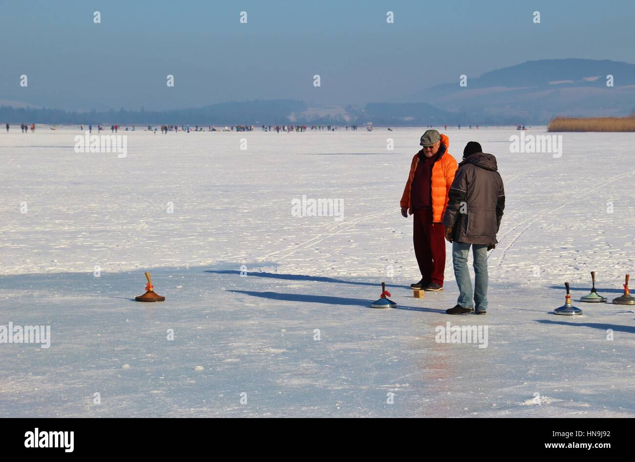 Männer spielen Eisstockschießen auf dem zugefrorenen See Wallersee in Seekirchen. Salzburger Land, Österreich, Europa. Stockfoto