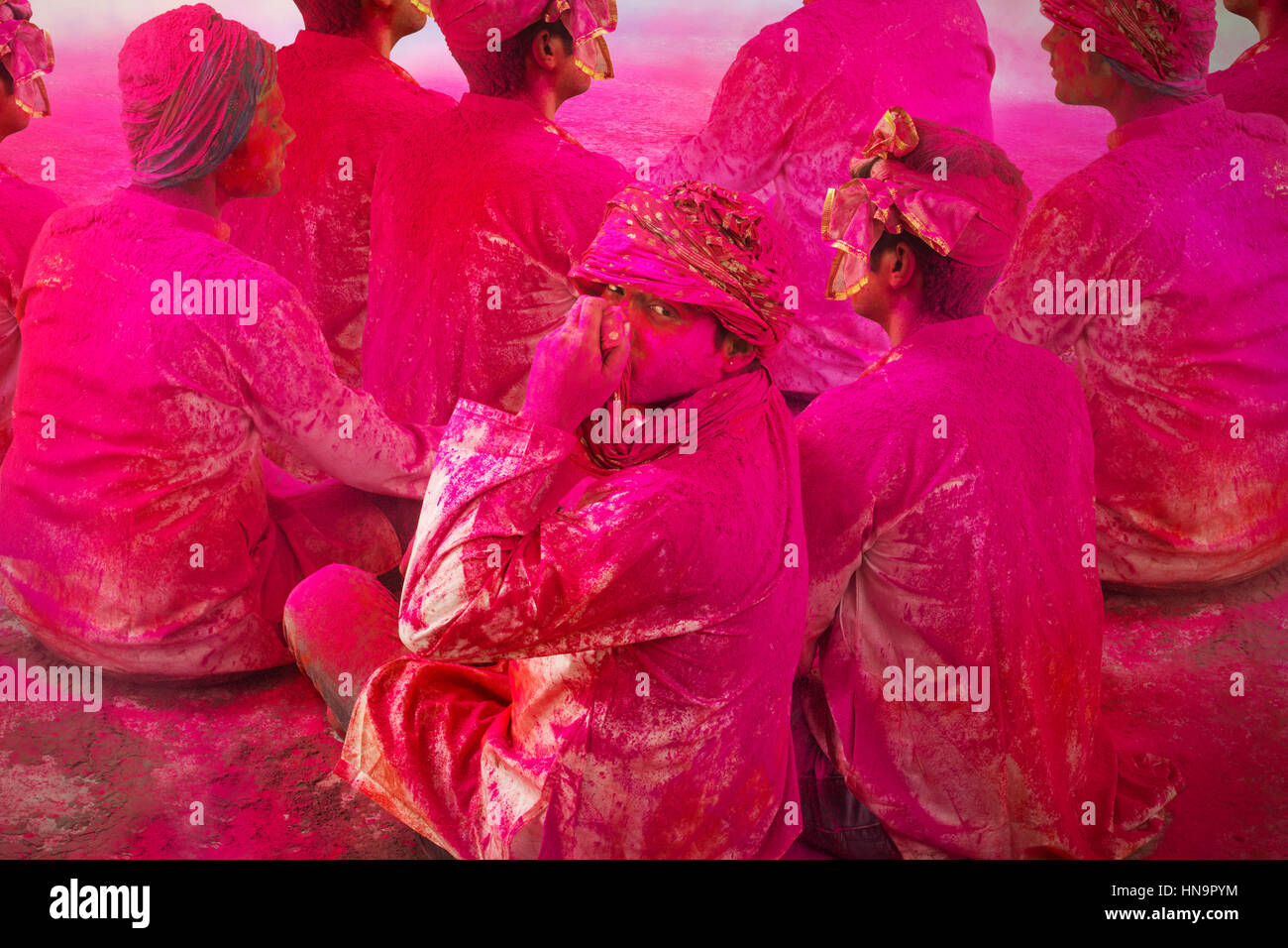 Jungen indischen Männer sitzen auf Boden, während Holi Farbe Festival in Farbpulver bedeckt. Stockfoto