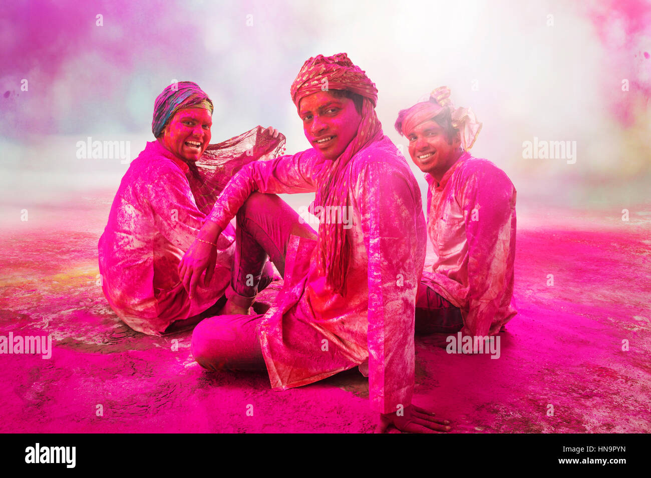 Jungen indischen Männer sitzen auf Boden, während Holi Farbe Festival in Farbpulver bedeckt. Stockfoto