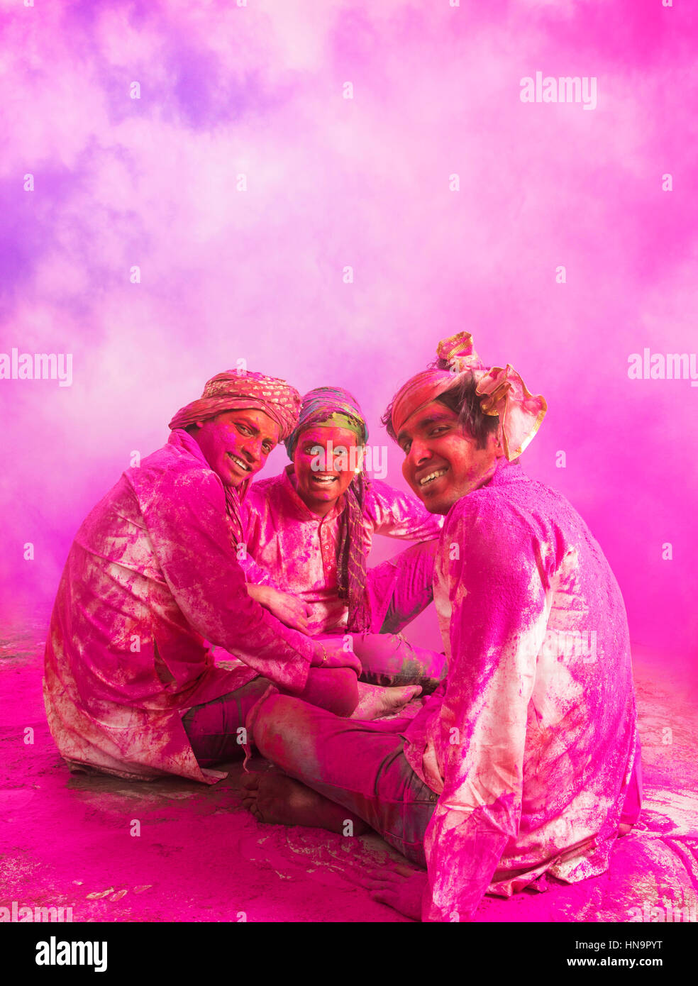 Jungen indischen Männer sitzen auf Boden, während Holi Farbe Festival in Farbpulver bedeckt. Stockfoto