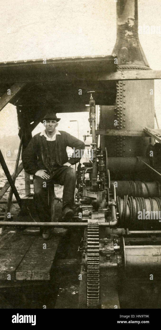 Antike c1920 Fotografie, Mann steht in der Nähe von Dampf betriebene Maschinen USA. Stockfoto