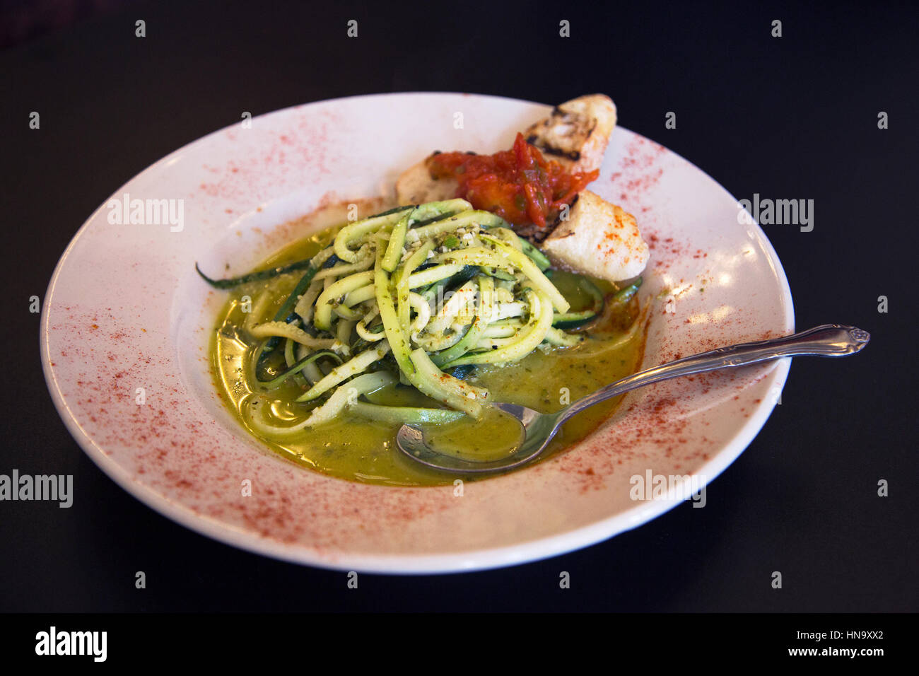 Leckere vegane Mahlzeit: Bänder von Sommerkürbis und Zucchini, Chardonnay-Sauce mit Knoblauch, Zitrone und Kräutern, und Crostini mit rotem Pfeffer Belag, Santa Fe Stockfoto