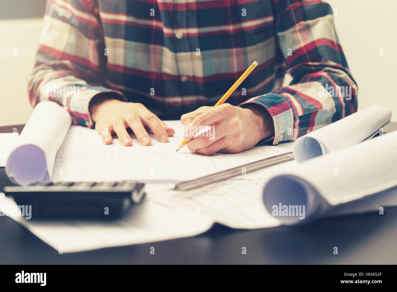 Bauingenieur auf Blaupause an seinem Arbeitsplatz im Büro Stockfoto
