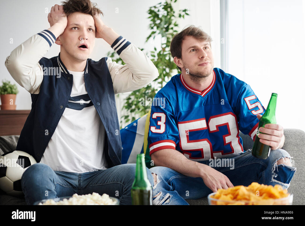 Zwei junge Erwachsene Männer Fußballspiel beobachten Stockfoto