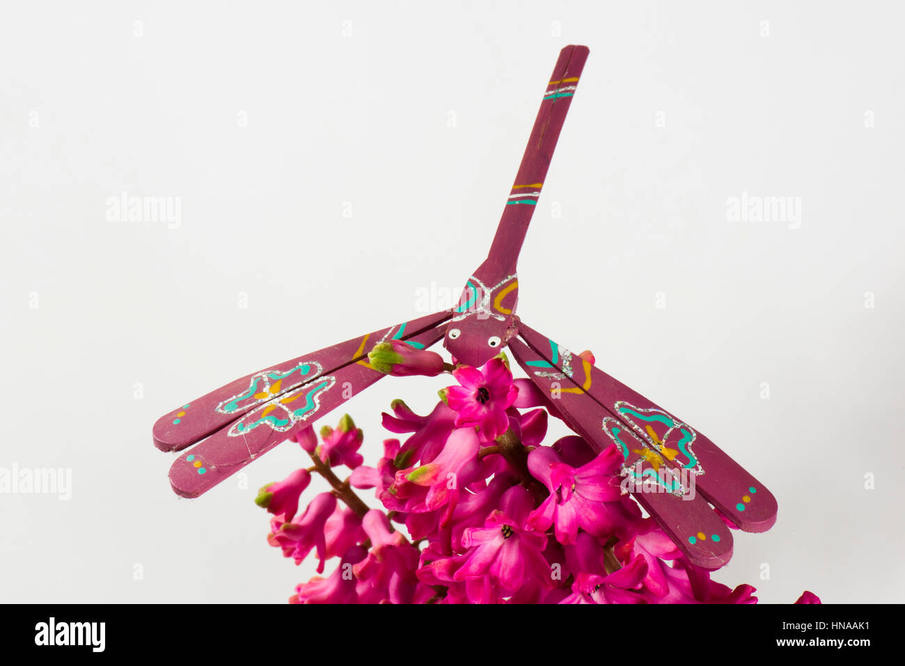Ausgleichende Spielzeug Libelle aus Bambus gefertigt und handbemalt balancieren auf einer Hyazinthe Blume Stockfoto