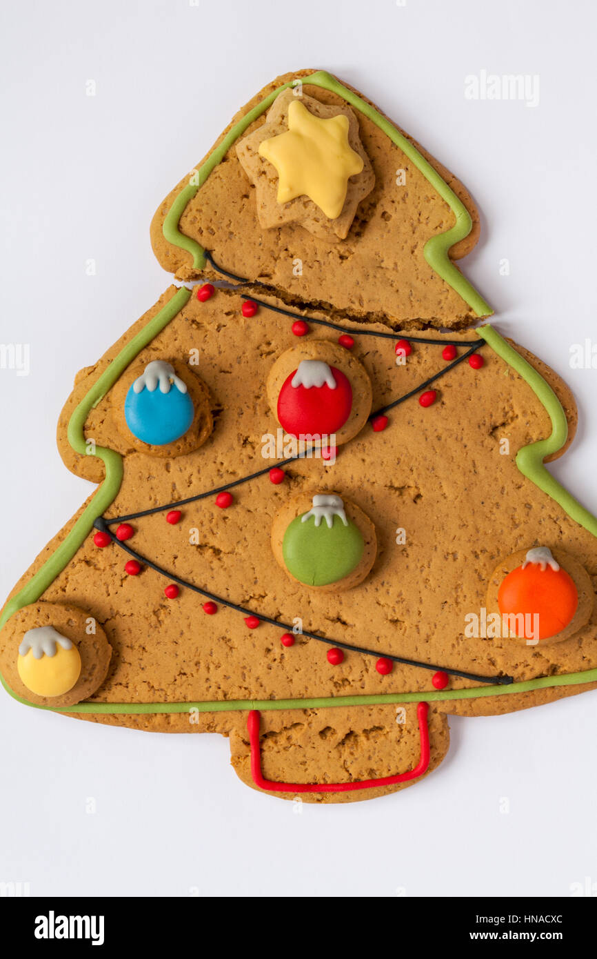 Gebrochen großen Iced Gingerbread Christmas Tree Biskuit mit süßen Kugeln verziert und Eistee Sterne Set auf weißem Hintergrund Stockfoto