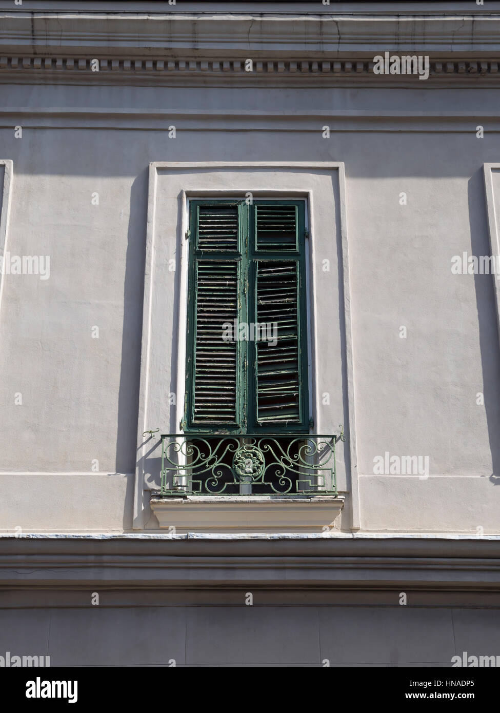 Groß grün bemalten Fensterläden aus Holz mit einer typischen verzierten Eisen Geländer auf einem Balkon in New Orleans Stockfoto