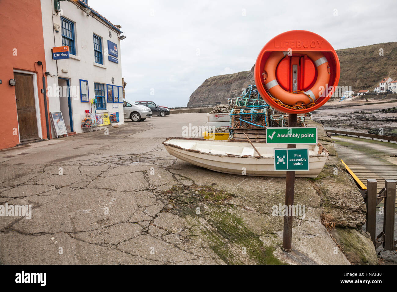 Feuer, Sammelplatz und Rettungsring am Hafen bei Staithes, North Yorkshire, England, UK Stockfoto