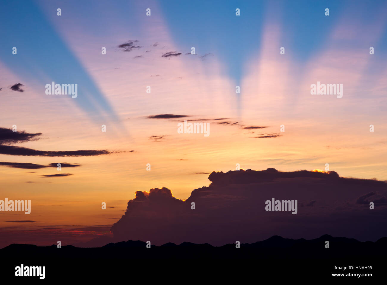 Anti-dämmerungsaktiv Sonnenstrahlen Leuchten hinter einem Sturm bei Sonnenuntergang. Stockfoto