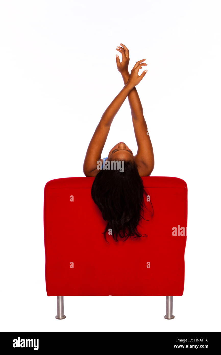 Afroamerikanische Frau in einem roten Stuhl sitzen. Stockfoto