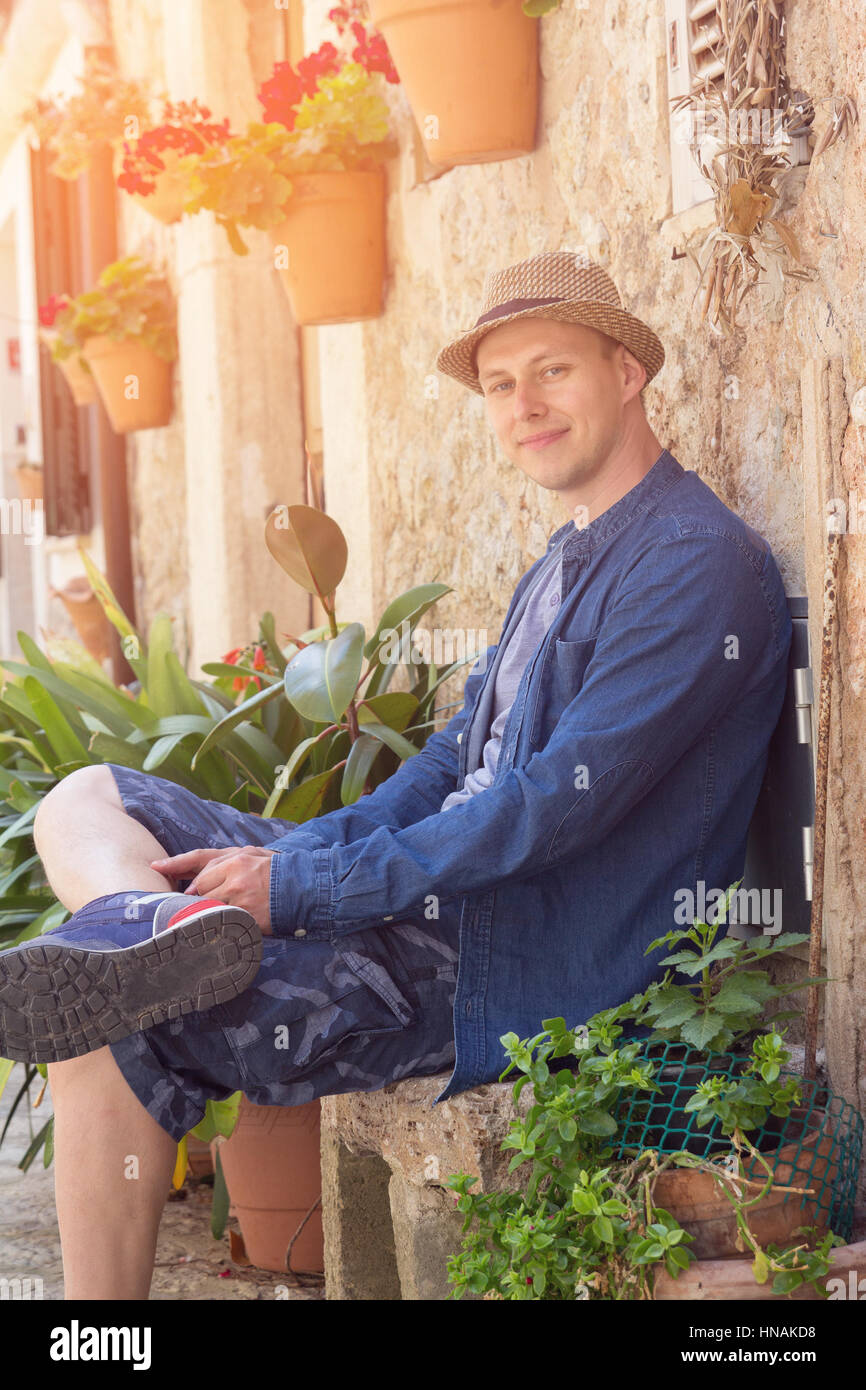 junge Touristen Mann sitzt auf mediterrane Straße Stockfoto