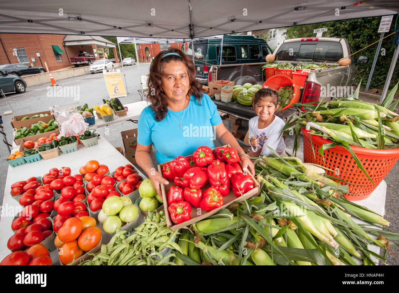 Hispanic Frau und Kind zeigen Produkte auf lokalen Maryland Bauernmarkt am Ostufer Marylands. Stockfoto