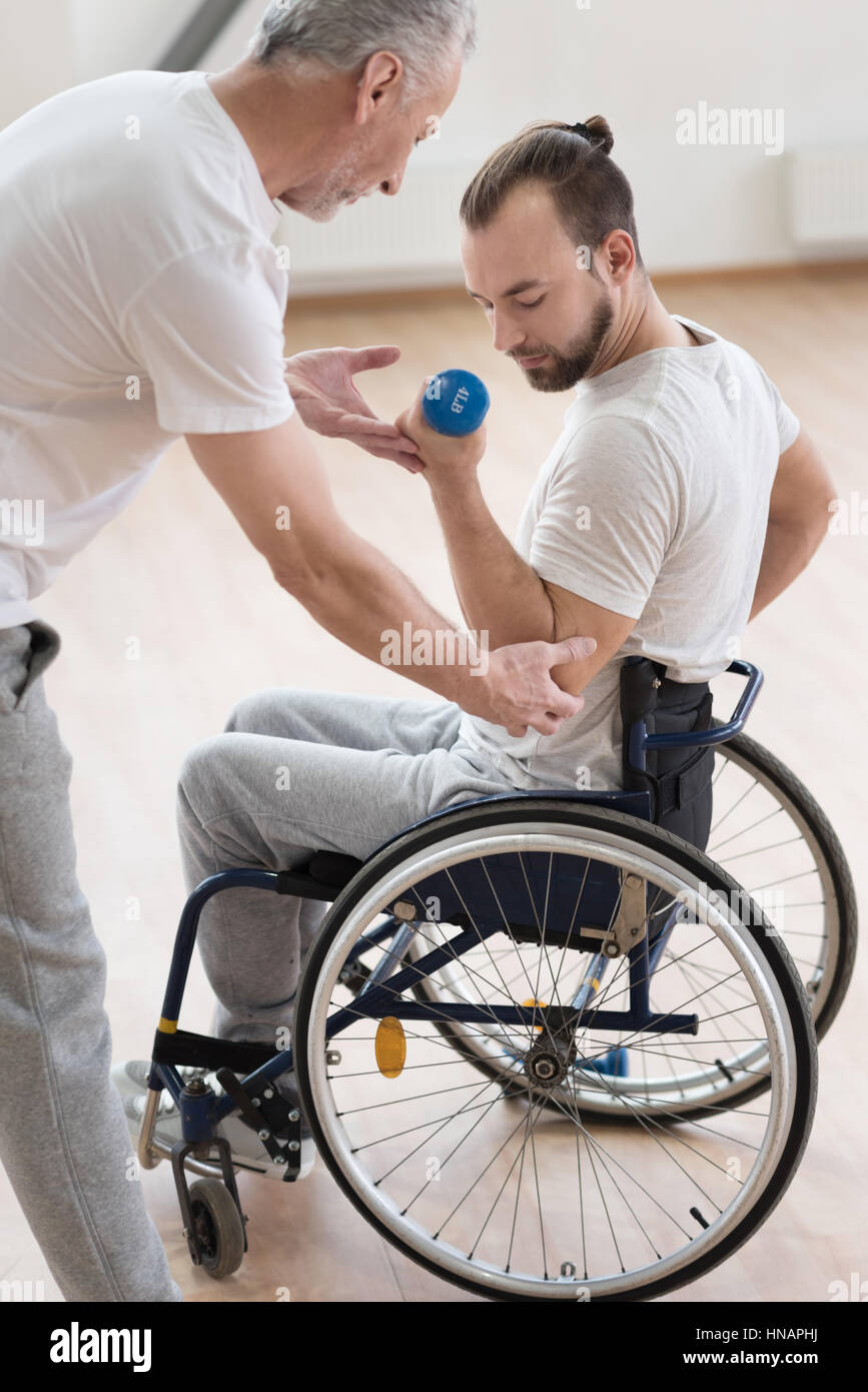 Beteiligten behinderte Mensch mit seinem Trainer im Fitness-Studio trainieren Stockfoto