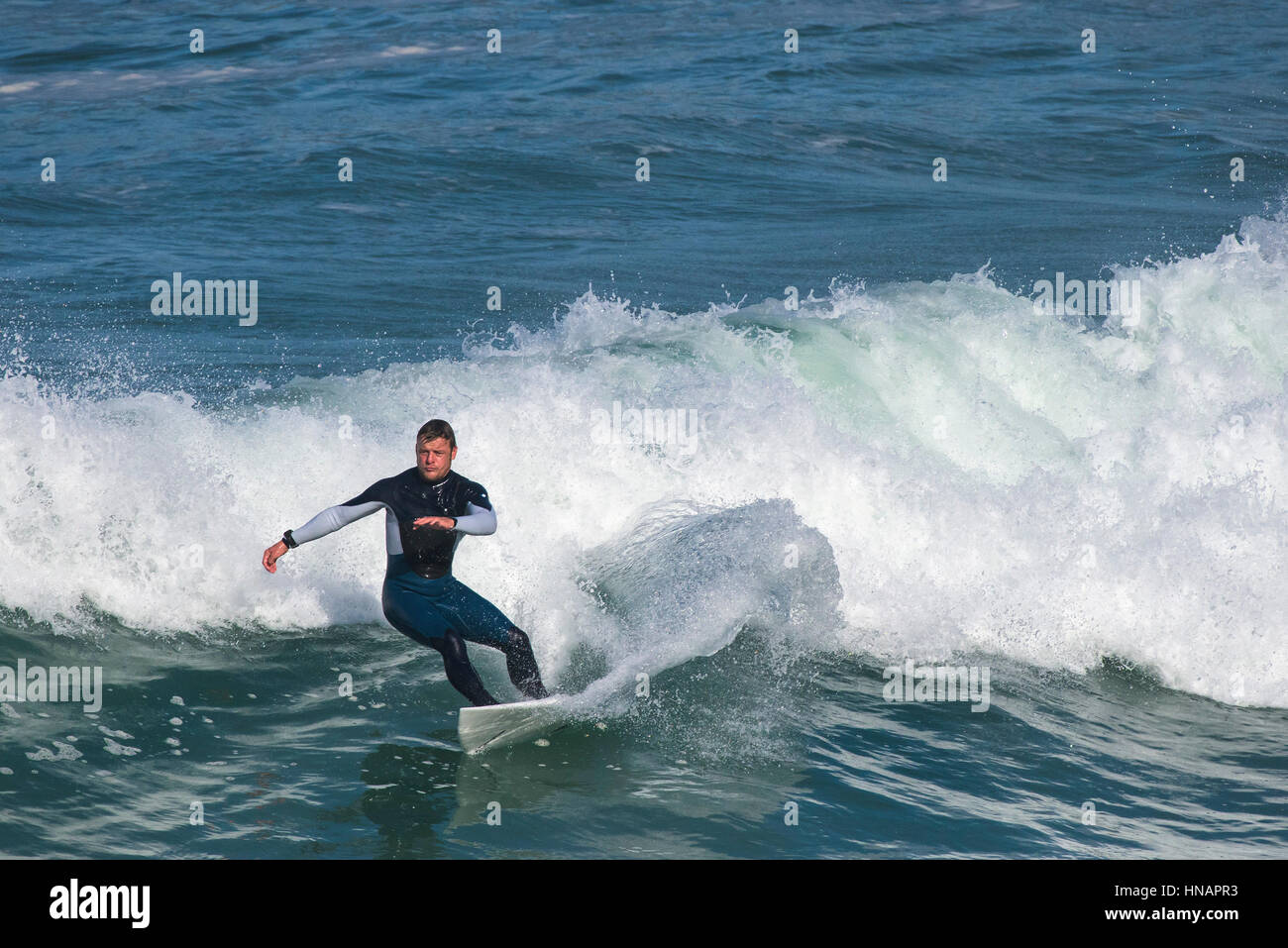Eine Surfer reitet eine Welle Sennen Cove in Cornwall. Stockfoto