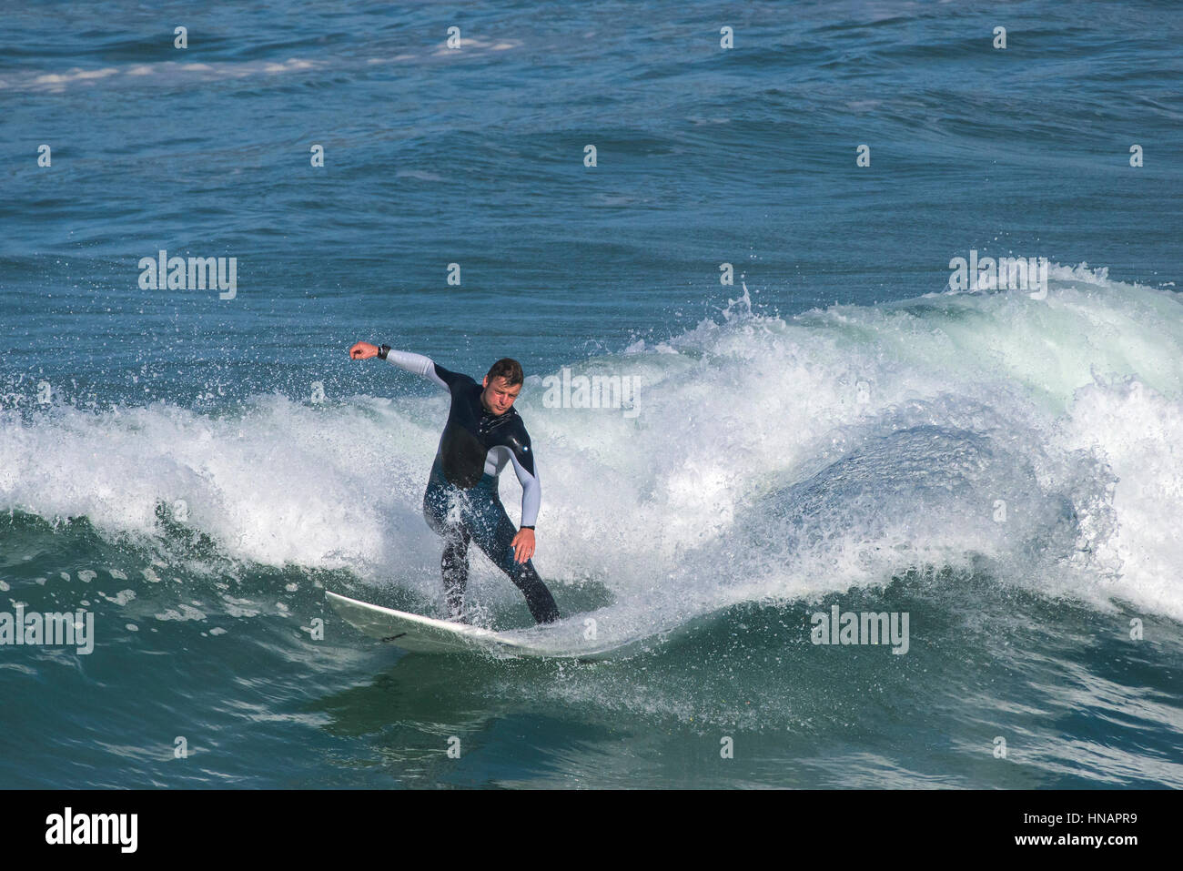 Eine Surfer reitet eine Welle Sennen Cove in Cornwall. Stockfoto