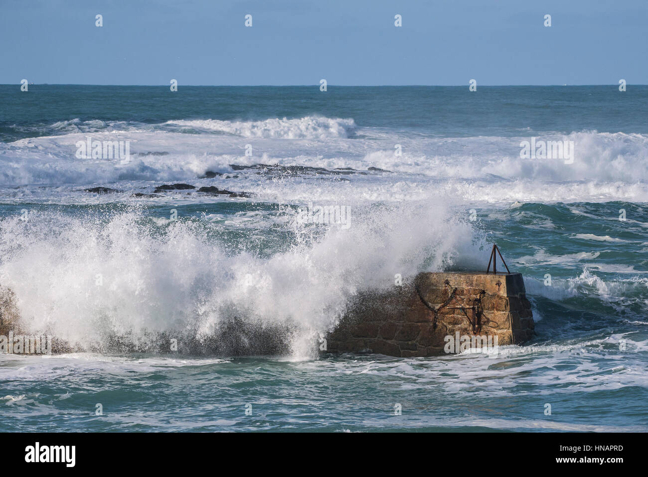 Starke Winde fahren Wellen über der Oberseite von der Mole in Sennen Cove, Cornwall, England. Großbritannien Wetter. Stockfoto